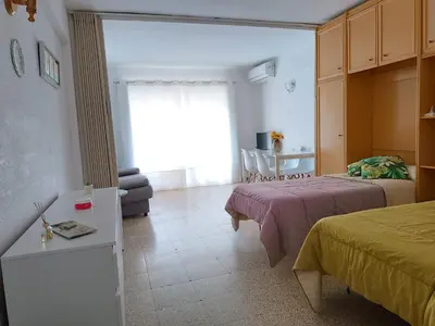 a bedroom with two beds and a couch and a window at Estudio Playa Cullera in Cullera