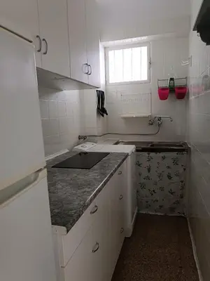 a small white kitchen with a sink and a window at Estudio Playa Cullera in Cullera
