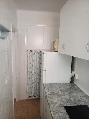 a kitchen with white cabinets and a white refrigerator at Estudio Playa Cullera in Cullera