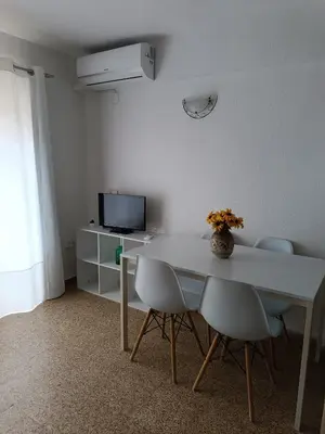 a white dining room table with chairs and a television at Estudio Playa Cullera in Cullera