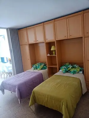 two beds in a room with cabinets at Estudio Playa Cullera in Cullera