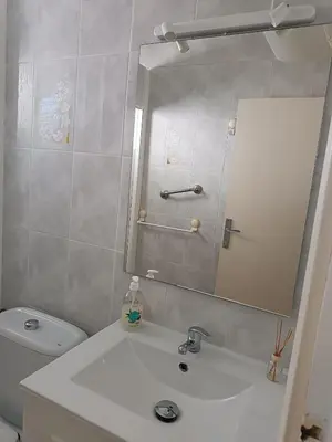 a bathroom with a sink and a mirror and a toilet at Estudio Playa Cullera in Cullera