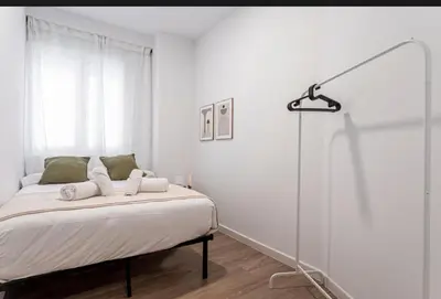 a white bedroom with a bed and a lamp at Lugre, Lovely flat close to center in Valencia