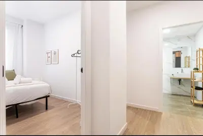 a white bedroom with a bed and a mirror at Lugre, Lovely flat close to center in Valencia