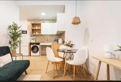 a kitchen and living room with a table and chairs at Lugre, Lovely flat close to center in Valencia
