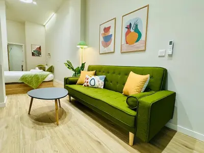 a living room with a green couch and a table at Stylish Design Studio in Valencia in Valencia