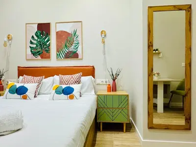 a bedroom with a bed with white sheets and a mirror at Stylish Design Studio in Valencia in Valencia