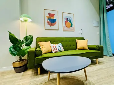 a living room with a green couch and a table at Stylish Design Studio in Valencia in Valencia