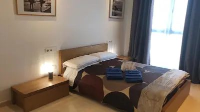 a bedroom with a bed with two blue bags on it at Direct view to the beach , Parking , Terraza in Valencia