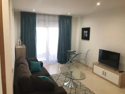 a living room with a couch and a television at Direct view to the beach , Parking , Terraza in Valencia