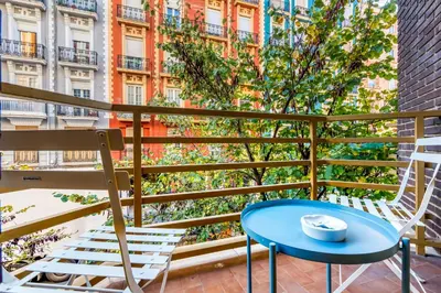 a table and chairs on a balcony with a view of a city at Centrally located temporary, very spacious Pataconabluerentals in Valencia