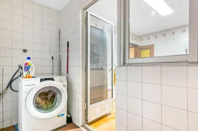 a laundry room with a washing machine and a window at Centrally located temporary, very spacious Pataconabluerentals in Valencia