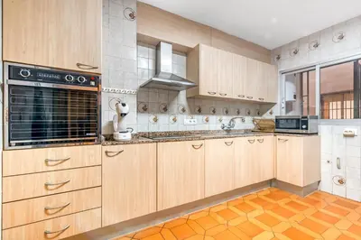 a kitchen with wooden cabinets and a stove top oven at Centrally located temporary, very spacious Pataconabluerentals in Valencia