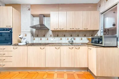 a kitchen with wooden cabinets and a microwave at Centrally located temporary, very spacious Pataconabluerentals in Valencia