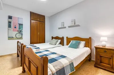 a bedroom with two beds and a table with a lamp at Centrally located temporary, very spacious Pataconabluerentals in Valencia