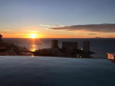 a view of the sunset from the rooftop of a building at Villa conectada al mediterraneo, Infinity pool in Faro de Cullera