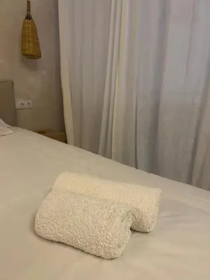 a white towel sitting on top of a bed at Oasis suites ruzafa in Valencia