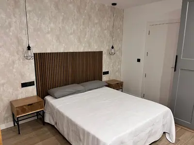 a bedroom with a white bed and two night stands at Loft en puerto de Valencia in Valencia