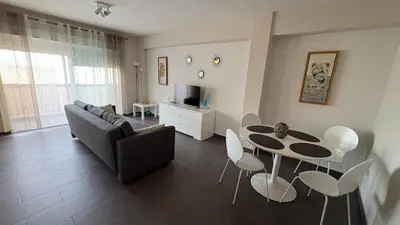 a living room with a couch and a table and chairs at Apartment near the beach in Valencia