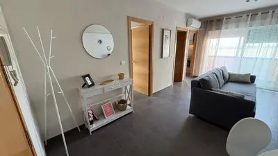 a living room with a couch and a mirror at Apartment near the beach in Valencia