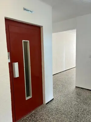 a red door in an office building with a mirror at Apartment near the beach in Valencia