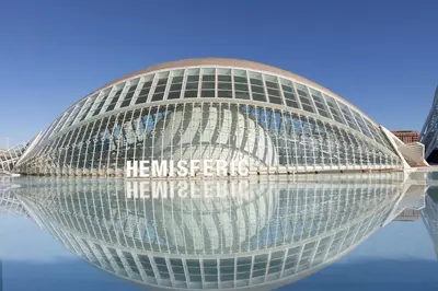 a large building with its reflection in the water at RM29 Loft Valencia - Espacioso estudio con terraza en zona Ayora in Valencia