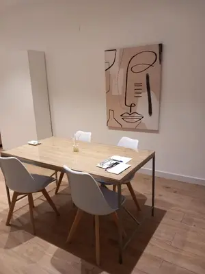a kitchen with a wooden table and white cabinets at Valencia Aparthotel HBB in Valencia