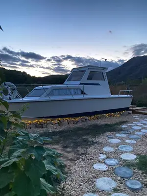 a white boat sitting on the shore at Barco Varado in Gandía
