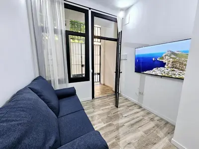 a living room with a blue couch and a flat screen tv at Apart Valencia A in Valencia