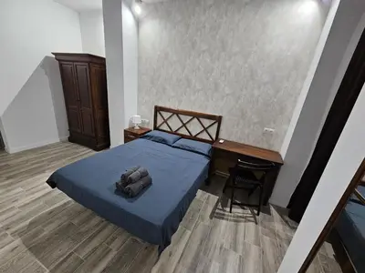 a bedroom with a blue bed and a desk and a table at Apart Valencia A in Valencia