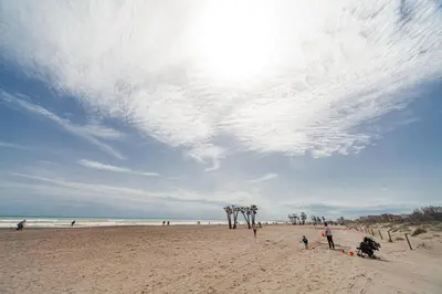 a group of people standing on a beach at Fantástico apartamento con todos los servicios in Canet de Berenguer
