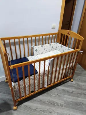 a wooden crib with a wooden chair in a room at Fantástico apartamento con todos los servicios in Canet de Berenguer