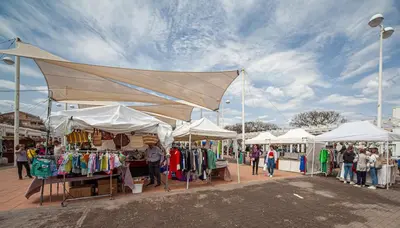 a group of people standing around a market with tents at Fantástico apartamento con todos los servicios in Canet de Berenguer