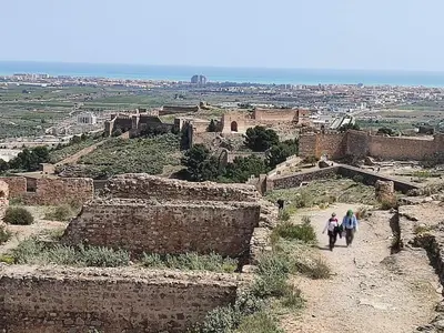 two people walking down a dirt path in an ancient city at Fantástico apartamento con todos los servicios in Canet de Berenguer