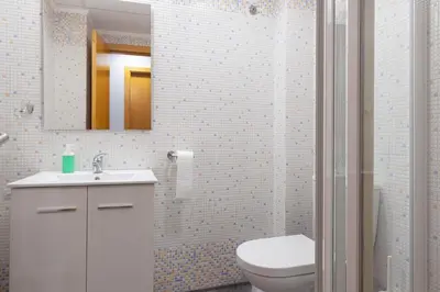 a bathroom with a toilet and a sink and a mirror at Fantástico apartamento con todos los servicios in Canet de Berenguer