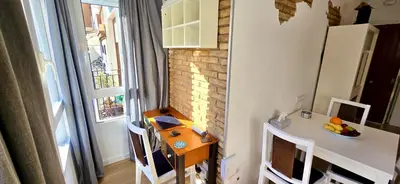 a small kitchen with a table and a table and a window at Reinapart Cabanyal in Valencia