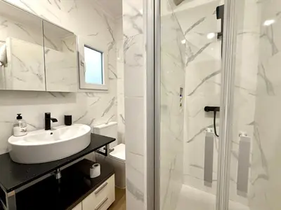 a white bathroom with a sink and a shower at Reinapart Cabanyal in Valencia
