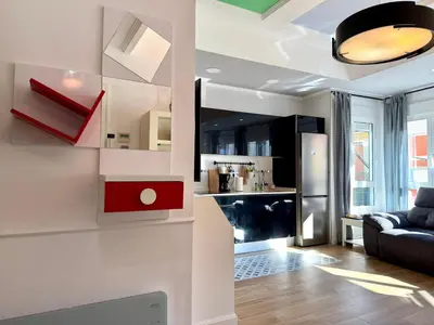 a living room with a couch and a kitchen at Reinapart Cabanyal in Valencia