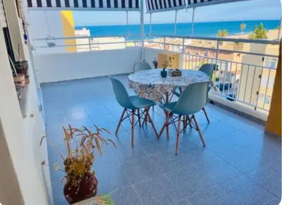 a table and chairs on a balcony with the beach at Lugar junto al mar in Casas Las Basas