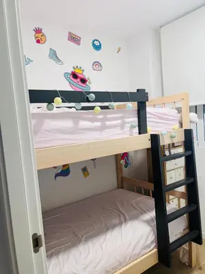 a bunk bed with a ladder next to a bunk bedessen at Lugar junto al mar in Casas Las Basas