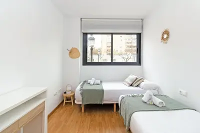 two beds in a white room with a window at GuestReady - Lovely home near the beach in Valencia