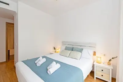 a bedroom with a large white bed with towels on it at GuestReady - Lovely home near the beach in Valencia