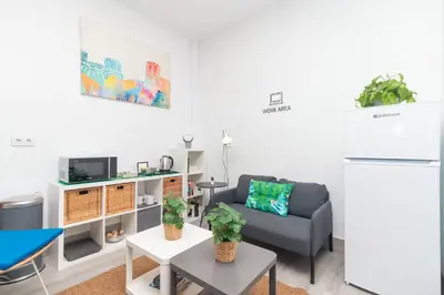 a living room with a couch and a refrigerator at Moreno Rooms by BET Apartments in Valencia
