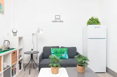 a living room with a couch and two potted plants at Moreno Rooms by BET Apartments in Valencia