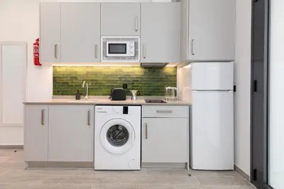 a kitchen with a washing machine and a refrigerator at Apartamento 1º nuevo cerca playa in Valencia