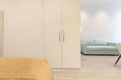 a living room with white cabinets and a couch at Apartamento 1º nuevo cerca playa in Valencia