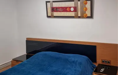 a bedroom with a bed with a blue comforter at Amazing Home In Macastre With Sauna in Macastre