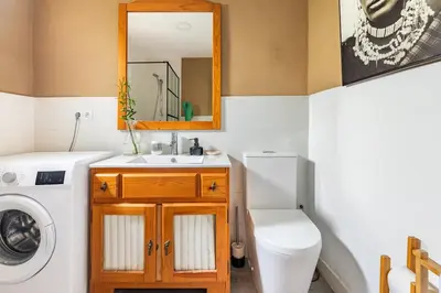 a bathroom with a sink and a washing machine at Les moreres a space for tranquility in Valencia