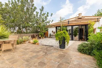 a garden with a patio and a house at Les moreres a space for tranquility in Valencia