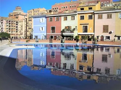 a large pool of water in a city with buildings at Charming apt by the beach with stunning harbor views in Port Saplaya